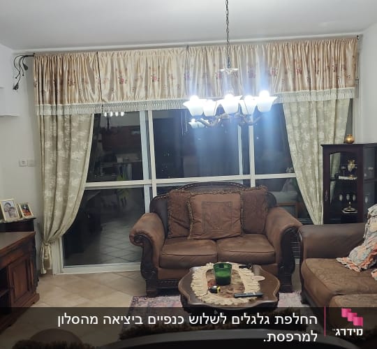 סלון עם ספות ווילונות ליד חלון גדול